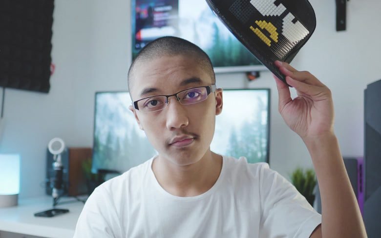 Man is Holding A Cap on to his Head