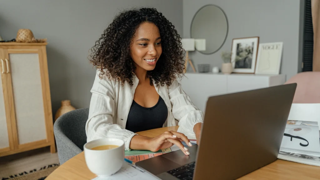 user using laptop having coffee