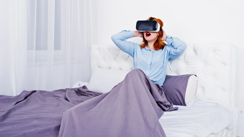 red-haired-girl-bed-with-vr-glasses-studio-room